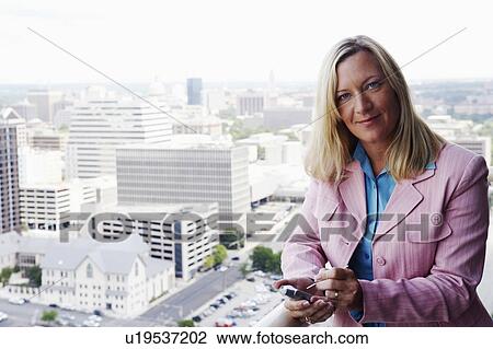 Stock Image - Portrait of a businesswoman using a personal data assistant. Fotosearch