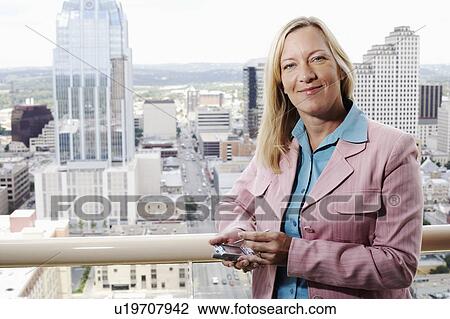 Stock Image - Portrait of a businesswoman using a personal data assistant. Fotosearch