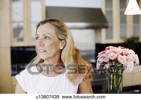 Close-up of a mature woman looking away View Large Photo Image Stock Photo - Close-up of a mature woman looking away. Fotosearch
