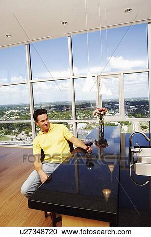 Stock Image - Mature man holding a glass of wine. Fotosearch