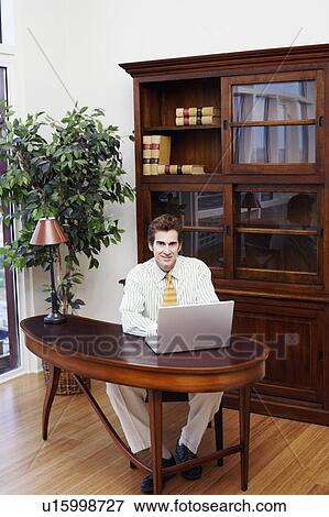 Portrait of a businessman using a laptop View Large Photo Image Stock Photo - Portrait of a businessman using a laptop. Fotosearch
