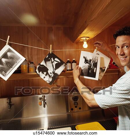 Portrait of a mature man holding photographs in a dark room View Large Photo Image Stock Image - Portrait of a mature man holding photographs in a dark room. Fotosearch