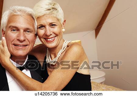 Portrait of a senior woman embracing a mature man View Large Photo Image Stock Photograph - Portrait of a senior woman embracing a mature man. Fotosearch