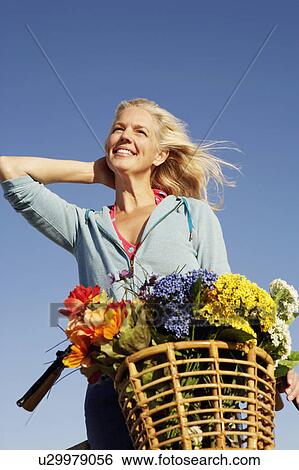 Low angle view of a mature woman with her hand in her hair and smiling View Large Photo Image Stock Photograph - Low angle view of a mature woman with her hand in her hair and smiling. Fotosearch