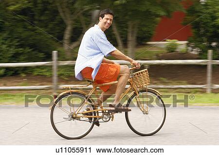 Stock Image - Side profile of a mature man cycling. Fotosearch