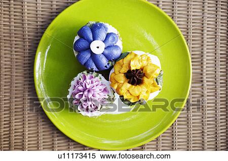 Stock Photography - Close-up of three cupcakes on a plate. Fotosearch