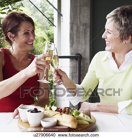 Close-up of two mature women toasting with champagne flutes View Large Photo Image Stock Image - Close-up of two mature women toasting with champagne flutes. Fotosearch