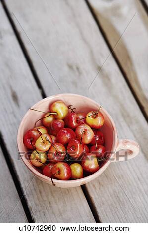 Stock Image - High angle view of cherries in a cup. Fotosearch