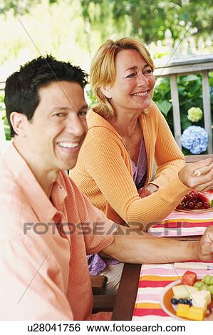Mature couple sitting at the table View Large Photo Image Stock Photograph - Mature couple sitting at the table. Fotosearch