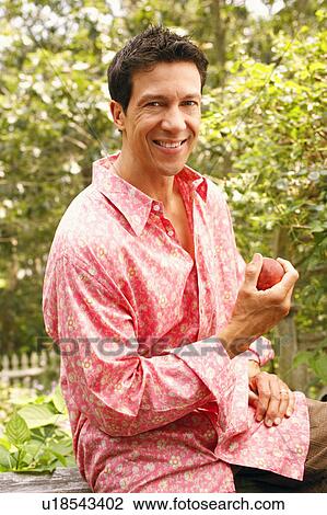 Portrait of a mature man holding an apple View Large Photo Image Stock Image - Portrait of a mature man holding an apple. Fotosearch