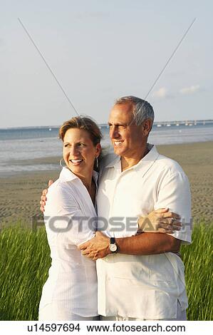 Close-up of a mature couple embracing on the beach View Large Photo Image Picture - Close-up of a mature couple embracing on the beach. Fotosearch