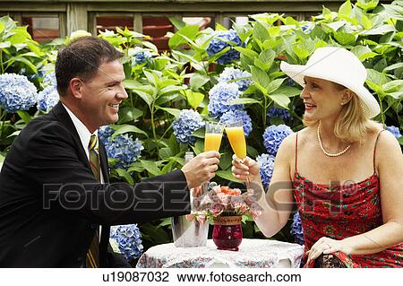 Close-up of a mature couple toasting glasses of juice View Large Photo Image Stock Image - Close-up of a mature couple toasting glasses of juice. Fotosearch