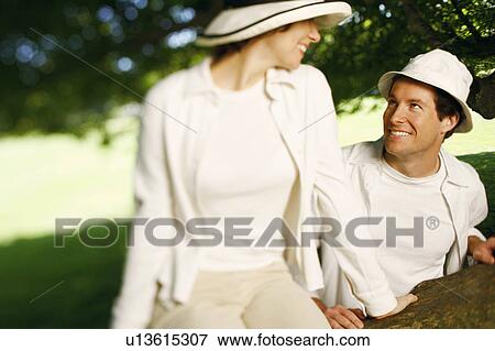 Stock Photo - Close-up of a mid adult couple looking at each other and smiling. Fotosearch