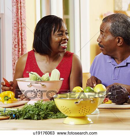 Mature couple cutting vegetables and talking View Large Photo Image Stock Image - Mature couple cutting vegetables and talking. Fotosearch