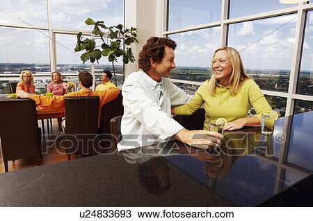 Stock Image - Mature couple sitting together and smiling. Fotosearch