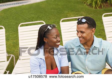 Stock Photo - Mature man and a mid adult woman looking at each other. Fotosearch