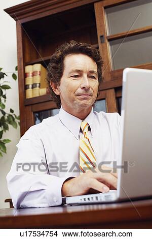 Picture - Businessman using a laptop. Fotosearch