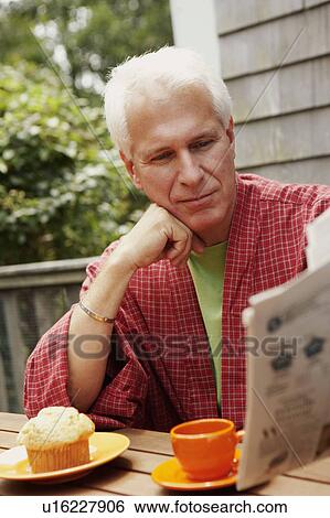 Close-up of a mature man reading a newspaper View Large Photo Image Stock Photograph - Close-up of a mature man reading a newspaper. Fotosearch