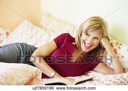 Close-up of a mature woman lying on the bed and laughing View Large Photo Image Stock Photograph - Close-up of a mature woman lying on the bed and laughing. Fotosearch