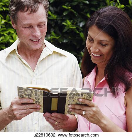 Stock Image - Mature couple reading a book. Fotosearch