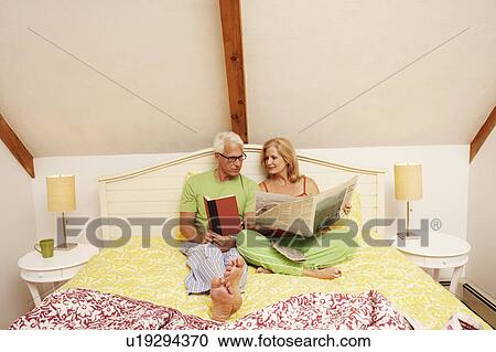 Stock Image - Mature couple sitting on the bed. Fotosearch