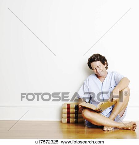 Mature man sitting on the floor and reading a book View Large Photo Image Stock Photography - Mature man sitting on the floor and reading a book. Fotosearch