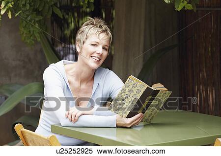 Portrait of a mature woman holding a book and smiling View Large Photo Image Stock Photography - Portrait of a mature woman holding a book and smiling. Fotosearch