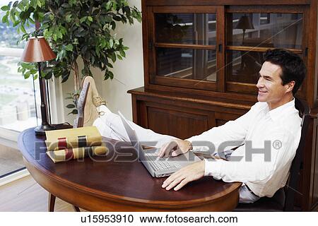 Side profile of a mature man using a laptop and smiling View Large Photo Image Stock Image - Side profile of a mature man using a laptop and smiling. Fotosearch