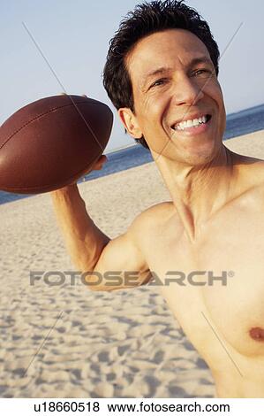 Close-up of a mature man playing football on the beach View Large Photo Image Stock Photo - Close-up of a mature man playing football on the beach. Fotosearch