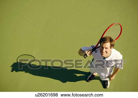 Stock Photo - High angle view of a mid adult man holding a tennis racket. Fotosearch