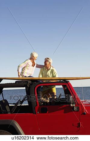 Mature couple smiling in a sports utility vehicle View Large Photo Image Picture - Mature couple smiling in a sports utility vehicle. Fotosearch