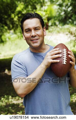 Picture - Portrait of a mature man holding a football. Fotosearch