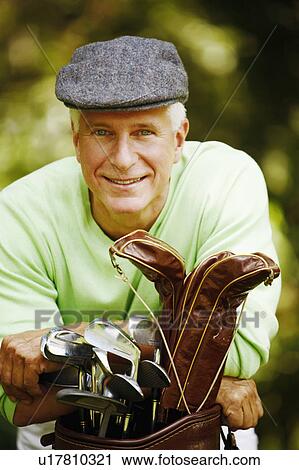 Portrait of a mature man leaning on a golf bag and smiling View Large Photo Image Stock Image - Portrait of a mature man leaning on a golf bag and smiling. Fotosearch
