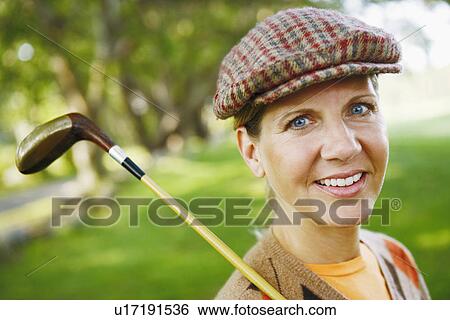 Stock Photograph - Portrait of a mature woman holding a golf club. Fotosearch