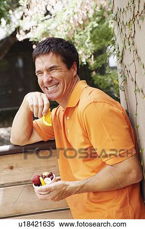 Close-up of a mature man holding a bowl of fruit View Large Photo Image Stock Photography - Close-up of a mature man holding a bowl of fruit. Fotosearch
