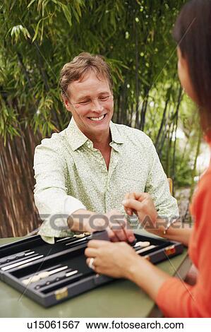 Close-up of a mature man playing backgammon with a mature woman View Large Photo Image Stock Photo - Close-up of a mature man playing backgammon with a mature woman. Fotosearch