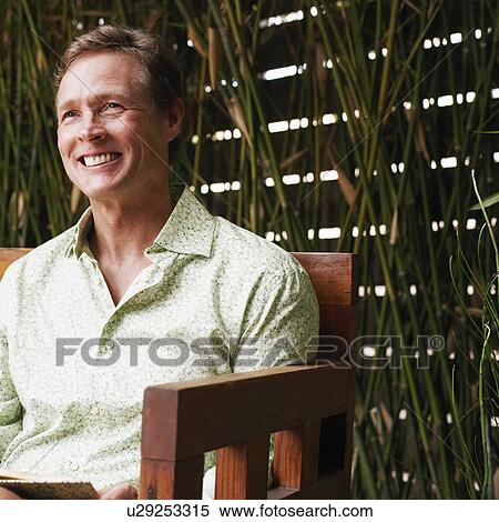 Close-up of a mature man sitting in an armchair and smiling View Large Photo Image Stock Photography - Close-up of a mature man sitting in an armchair and smiling. Fotosearch