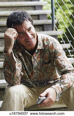 Close-up of a mature man sitting on a staircase and holding a personal data assistant View Large Photo Image Stock Photo - Close-up of a mature man sitting on a staircase and holding a personal data assistant. Fotosearch