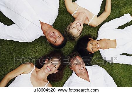 High angle view of two mature men and three mature women lying on the grass View Large Photo Image Stock Image - High angle view of two mature men and three mature women lying on the grass. Fotosearch