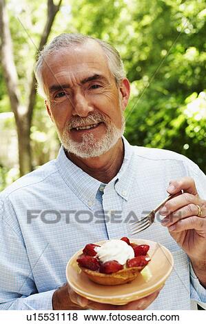 Portrait of a mature man eating tart with a fork View Large Photo Image Stock Photo - Portrait of a mature man eating tart with a fork. Fotosearch