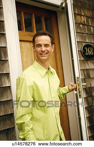 Portrait of a mature man holding a door handle and smiling View Large Photo Image Stock Photograph - Portrait of a mature man holding a door handle and smiling. Fotosearch