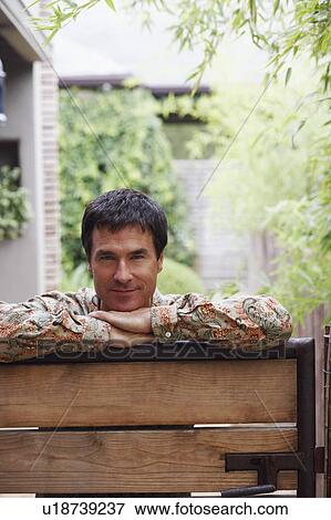 Portrait of a mature man leaning on a gate View Large Photo Image Stock Photo - Portrait of a mature man leaning on a gate. Fotosearch