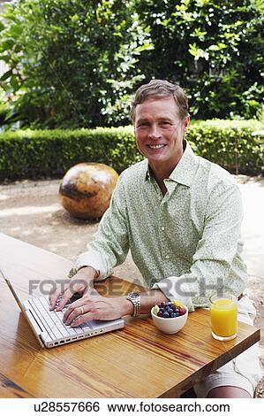 Portrait of a mature man working on a laptop View Large Photo Image Stock Photograph - Portrait of a mature man working on a laptop. Fotosearch