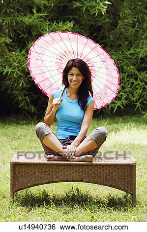 Portrait of a mature woman holding a parasol and smiling View Large Photo Image Stock Photograph - Portrait of a mature woman holding a parasol and smiling. Fotosearch