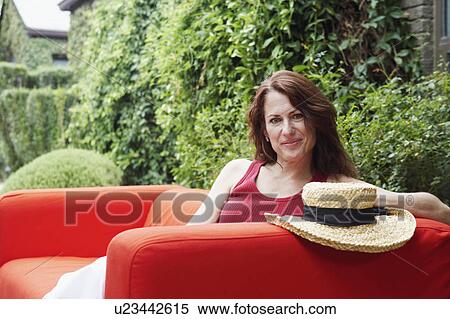 Stock Photography - Portrait of a mature woman sitting in an armchair. Fotosearch