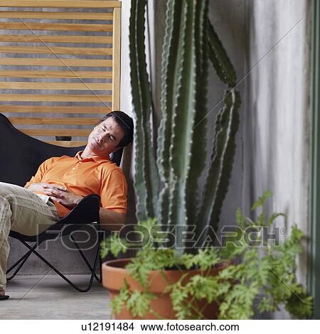 Picture - Side profile of a mature man sitting on a chair and sleeping. Fotosearch