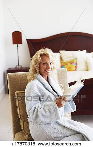 Portrait of a mid adult woman holding a book and smiling View Large Photo Image Stock Photo - Portrait of a mid adult woman holding a book and smiling. Fotosearch