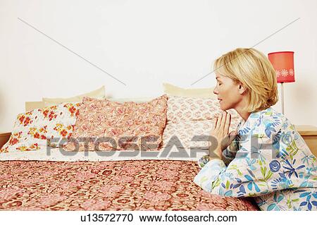 Side profile of a mature woman praying in a bedroom View Large Photo Image Stock Image - Side profile of a mature woman praying in a bedroom. Fotosearch