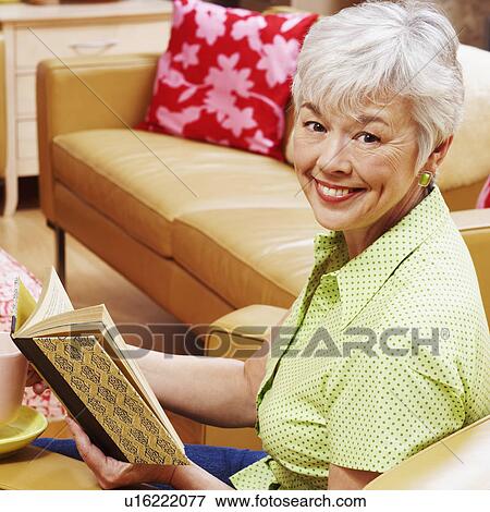 Stock Photo - Portrait of a senior woman holding a book and smiling. Fotosearch