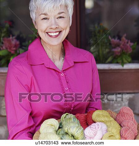 Portrait of a senior woman sitting and holding a bowl of woolen balls View Large Photo Image Stock Image - Portrait of a senior woman sitting and holding a bowl of woolen balls. Fotosearch